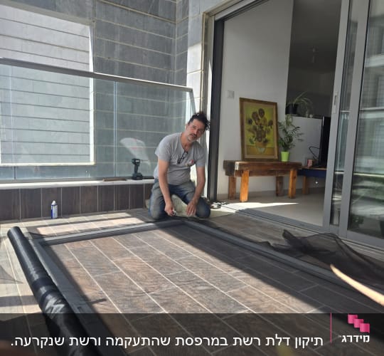 אדם עובד על מסגרת אלומיניום במרפסת